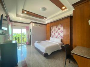 Cette chambre d'hôtel comprend un lit et un balcon. dans l'établissement โรงแรมสบาย พาเลซ, à Nakhon Si Thammarat