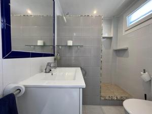 y baño blanco con lavabo y ducha. en Apartamentos Can Marsalet en Puerto Colom