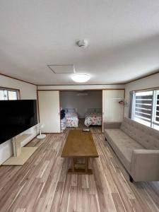 a living room with a couch and a flat screen tv at 駅徒歩２分の貸切一軒家【Villa Kokusai】 in Naha
