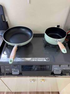 two pans sitting on top of a stove at 駅徒歩２分の貸切一軒家【Villa Kokusai】 in Naha