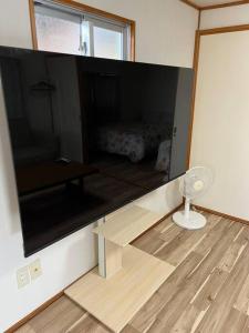 a room with a mirror and a table and a bed at 駅徒歩２分の貸切一軒家【Villa Kokusai】 in Naha