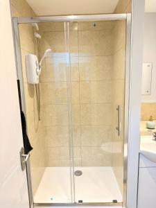 W łazience znajduje się prysznic ze szklanymi drzwiami. w obiekcie Comfortable City Apartment w mieście Derby