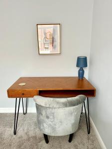 a wooden desk with a chair and a lamp at Comfortable City Apartment in Derby