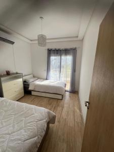 a bedroom with a bed and a window at appartement résidence Palm Beach Saidia in Oujda