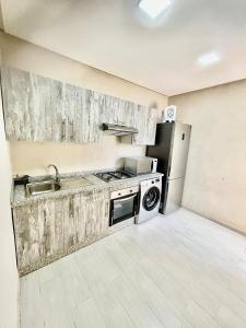 a kitchen with a sink and a stove and a refrigerator at appartement résidence Palm Beach Saidia in Oujda