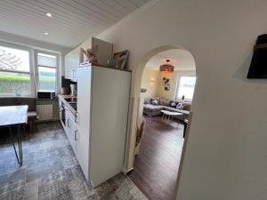 uma cozinha e sala de estar com um frigorífico branco num quarto em Fischerbalje Bantje Wohnung 1 em Borkum