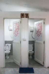 łazienka z dwoma toaletami i dwoma drzwiami w obiekcie World Citizen Hostel w mieście Baan Tai