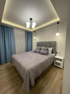 een slaapkamer met een groot bed en blauwe gordijnen bij Myfair apartment in Istanbul