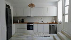 a kitchen with white cabinets and a sink at Lydia's Charming House in Naoussa in Naousa