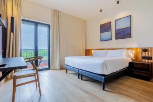 een slaapkamer met een bed, een bureau en een raam bij Hotel Acta Madfor in Madrid