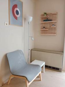 a room with a chair and a table and a lamp at Cherry - HappyHostGr - Downtown Apartment in Volos