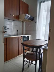 a kitchen with a wooden table and a small table and chairs at Cherry - HappyHostGr - Downtown Apartment in Volos