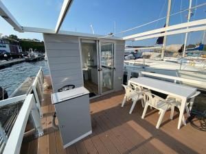 una mesa y sillas en la cubierta de un barco en Casa flotante con terraza en un marco inigualable, en Ribadeo