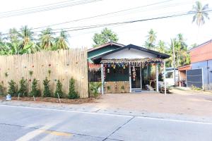 una casa con una valla al lado de una calle en World Citizen Hostel, en Baan Tai