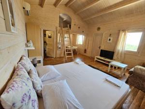 a large white bed in a room with wooden walls at Valerian in Agios Nikitas