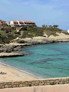 a beach with a house on top of a hill at Casa sul mare in Porto Torres