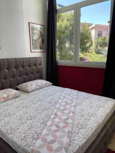 a bedroom with a bed and a large window at Casa sul mare in Porto Torres