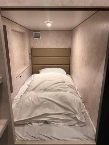 uma grande cama branca num pequeno quarto em Book Tea Bed SHIBUYA em Tóquio