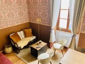 ein Wohnzimmer mit einem Stuhl und einem Tisch in der Unterkunft Une maison de famille in Oloron-Sainte-Marie