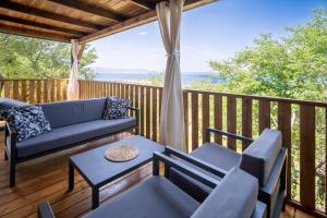 a deck with a couch and chairs and a table at Luxury Home Sanella in Klenovica