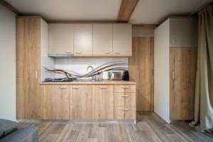 a kitchen with wooden cabinets and wooden floors at Luxury Home Sanella in Klenovica