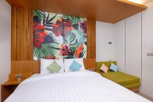 een slaapkamer met een groot wit bed en een tropische muurschildering bij Aralea Coliving in Denpasar