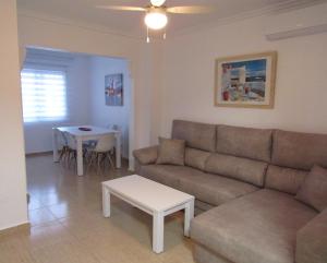 ein Wohnzimmer mit einem Sofa und einem Tisch in der Unterkunft Tui Casa in Puerto Marino