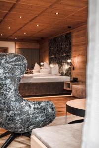 uma sala de estar com uma cama e uma cadeira em Hotel Unterwirt em Reit im Winkl