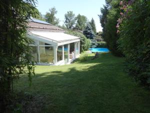 um jardim com um pavilhão e uma piscina em Gästehaus Ehrlich em Prien am Chiemsee