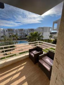 a balcony with two couches and a pool and buildings at appartement résidence Palm Beach Saidia in Oujda