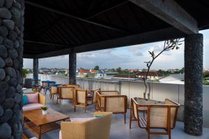 a patio with tables and chairs on a roof at Aralea Coliving in Denpasar