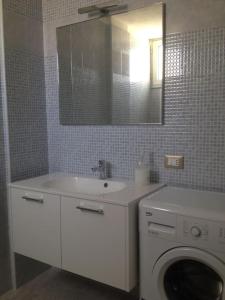 a bathroom with a washing machine and a sink at Coral Bay Suite Gallipoli in Gallipoli