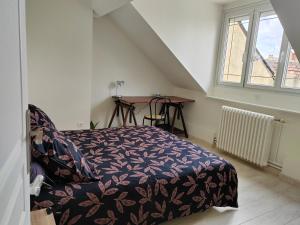 Schlafzimmer mit einem Bett, einem Tisch und einem Fenster in der Unterkunft L'Escale, chambres chez l'habitant in Le Mans