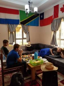 een groep mensen in een woonkamer bij Maasai Hostel Tanzania in Arusha