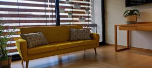 a yellow couch in a living room with a window at Comfortable studio in Kavála