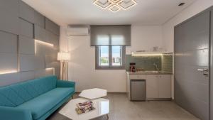 ein Wohnzimmer mit einem blauen Sofa und einer Küche in der Unterkunft Annarita in Adamas