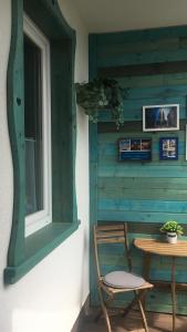 a wooden table and a chair next to a window at Szeged Pu-Ma Apartman in Szeged