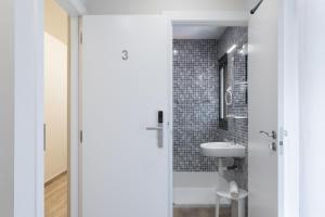 bagno bianco con lavandino e servizi igienici di Hostal Oliveta a Barcellona