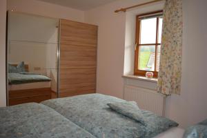 1 dormitorio con cama y ventana en Haus letzte Rose en Rieden am Forggensee