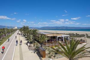 a beach with palm trees and people walking on a road at Pierluigi's House in Cagliari
