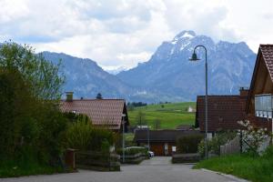 una montaña en la distancia con casas y un semáforo en Haus letzte Rose en Rieden am Forggensee