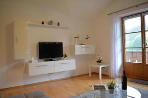 una sala de estar con TV en un armario blanco en Haus letzte Rose en Rieden am Forggensee
