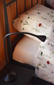 a bed with a pillow with flowers on it at Den Hooimijt in Kats