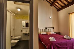 a bedroom with a bed and a sink and a toilet at Ostello Antica Filanda in Santa Sofia