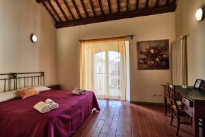 a bedroom with a bed and a desk and a window at Ostello Antica Filanda in Santa Sofia