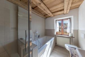 a bathroom with a tub and a glass shower at Malgorerhof Mathilde in San Genesio Atesino