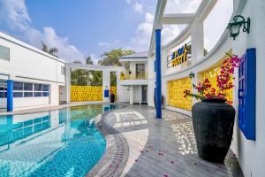 KanījRoadies Rostel - Best Adventure Resort in Ahmedabad的一座别墅,设有游泳池和鲜花花瓶