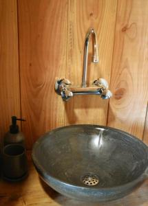 a sink in a bathroom with a wooden wall at Den Hooimijt in Kats