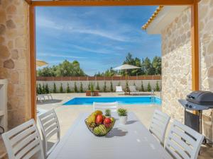 a dining table with a bowl of fruit on it at Villa Aqua - Laganas Stone Villas in Laganas