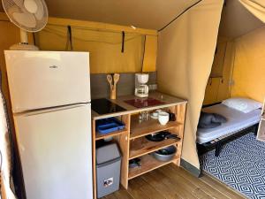 uma pequena cozinha com frigorífico numa tenda em LES EYCHECADOUS em Artigat
